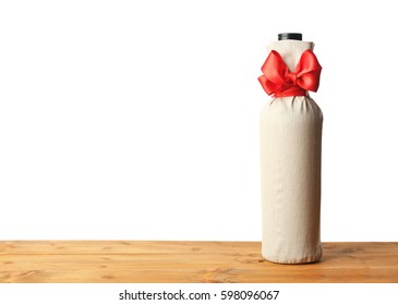 Table with wine bottle in gift bag on white background - Powered by Shutterstock