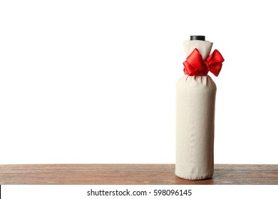 Table With Wine Bottle In Gift Bag On White Background