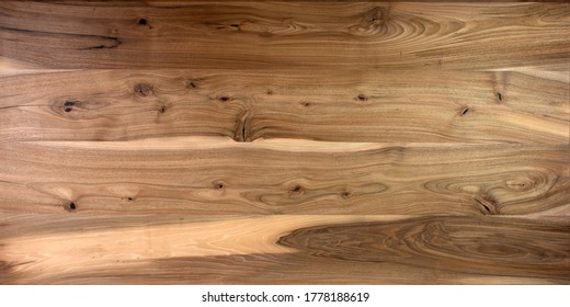 Table Wooden Surface From Natural Walnut. Rich Wood Grain Texture Background With Knots And Strong Lines. Copy Space