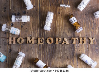 Table with written text  Homeopathy,  homeopathy globules and bottles
