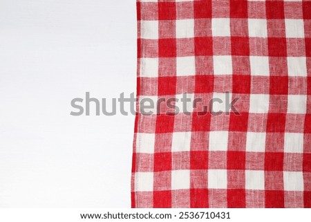 Tablecloth with checkered pattern on white wooden table, top view. Space for text