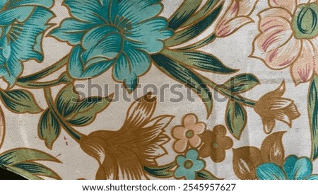 The tablecloth has a smooth, fabric texture with a floral design, featuring soft, raised patterns of flowers in various colors, giving it a gentle, elegant appearance.