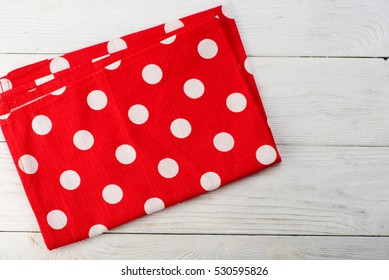 Tablecloth at polka dots. Red rustic napkin isolated on white wooden table. Copy space. Top view. - Powered by Shutterstock