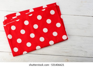 Tablecloth at polka dots. Red rustic napkin isolated on white wooden table. Copy space. Top view. - Powered by Shutterstock