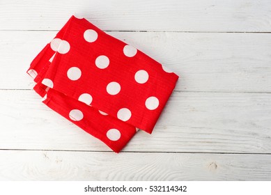 Tablecloth at polka dots. Red rustic napkin isolated on white wooden table. Copy space. Top view. - Powered by Shutterstock