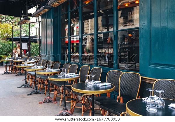 Tables and\
chairs in outdoor cafe in Paris,\
France.