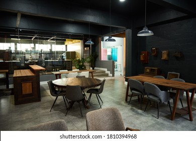 Tables And Chairs Sitting Empty In The Lounge Area Of A Large Modern Office Space After Business Hours