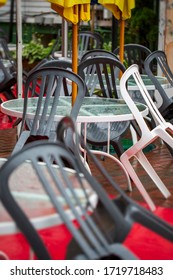 Tables And Chairs Stacked Together On Outdoor Patio Of An Empty Restaurant On Rainy Day