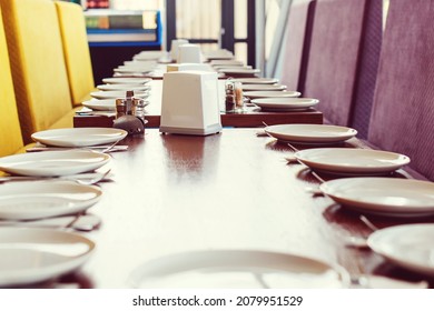 Tables Set For Meal In Modern Cafeteria. A Lot Of White Ceramic Plates On A Banquet Table. Served Table For Group Of People. Clean Canteen In Modern School. Lunch Room.