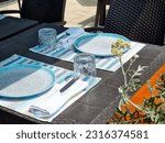 Tables with white tablecloth and chairs in restaurant, glasses on table.Empty cafe tables on veranda of restaurant.leisure, travel and tourism concept - served table at open-air restaurant on beach