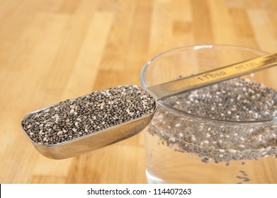 Tablespoon Of Chia Seeds With Chia Seeds Soaking In A Glass Of Water