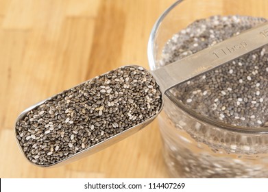 Tablespoon Of Chia Seeds With Chia Seeds Soaking In A Glass Of Water