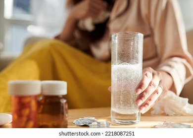 Tablet Of Aspirin Dissolving In Glass Of Water On Bed Table Of Sick Woman