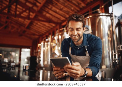 Tablet, beer and brewery with man in factory for production, manufacturing and alcohol fermentation. Technology, inspection and digital with business owner for distillery, storage and quality control - Powered by Shutterstock