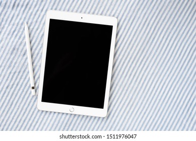 Tablet with black blank screen with pencil. flat lay. Top view with copy space. White background with grey stripes. workspace.
