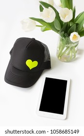 Tablet With Black Trucker Hat Spring Theme.