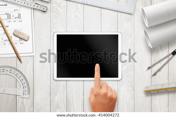Tablet with\
blank screen for mockup on architect work desk. Construction\
projects, and drawing equipment. Top\
view.