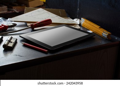 Tablet With Blank Screen On A Dark Cupboard With A Set Of Tools In A Dirty Basement