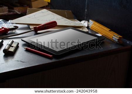 Tablet With Blank Screen On A Dark Cupboard With A Set Of Tools In A Dirty Basement