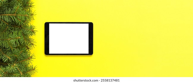 Tablet with blank screen on the yellow pastel color background. Top view with christmas decor. - Powered by Shutterstock