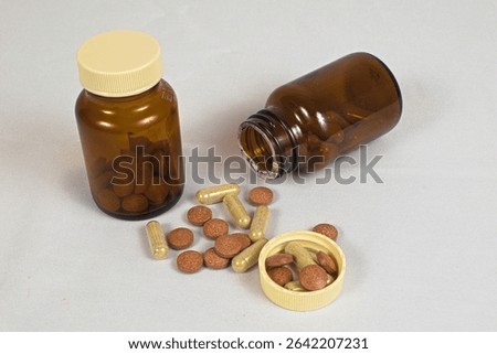 Tablet and capsule forms of supplements are displayed next to two pill bottles.