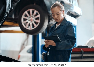 Tablet, checklist and woman in workshop with car service, maintenance or online motor insurance. Tech, engine and female mechanic in garage on digital app for inspection, repair and quality assurance - Powered by Shutterstock