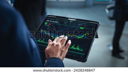 Tablet Computer Display with Real-Time Stocks, Commodities, Exchange Market Charts with Tickers. Anonymous Investment Trader Using Device in a Financial Business Office or Stock Exchange Floor