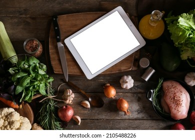 Tablet Computer With Fresh Vegetables On Dark Wooden Table In Kitchen