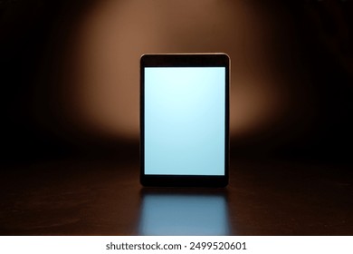 Tablet computer on dark surface with spotlight