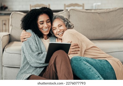 Tablet, daughter hug and happy senior mother with digital photo album, bonding and enjoy quality time together at home. Living room floor, memory and biracial family, people or mom and girl embrace - Powered by Shutterstock