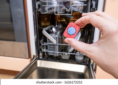 A Tablet Of A Detergent For Washing Dishes In Dishwashing Machine In Female Hand.