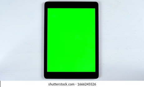 Tablet with a green background.