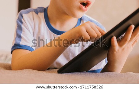 Tablet in the hands of a child. Study remotely. Recreation and entertainment for the home.Computer games.