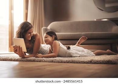 Tablet, happy mom and kid relax in home for learning, education or game. Digital technology, mother and girl child on floor in living room for streaming movie, video and family watch show together - Powered by Shutterstock