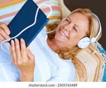 Tablet, headphones and senior woman on patio, happy and relax with movies, thinking and retirement at house. Watch, app and old person with subscription of film, smile and grandma with peace at home - Powered by Shutterstock