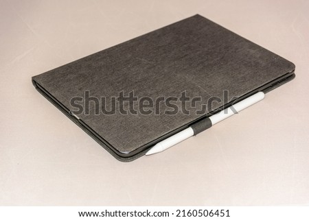 tablet and his pencil on a table in a protective case