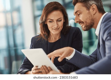 Tablet, meeting or planning with a business man and woman in the office for research on a company project. Collaboration, technology and brainstorming with corporate team talking strategy at work - Powered by Shutterstock