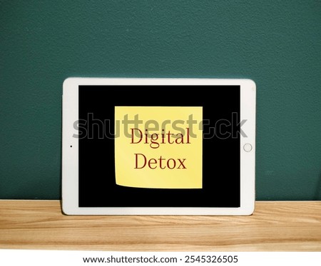 Tablet mobile computer with stick note written Digital Detox  - take a break from smartphone or unplugging from technology to reconnect with your inner self and regain control over your life