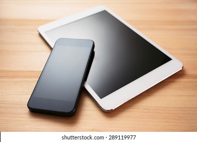 Tablet And Mobile Phone On A Wooden Table