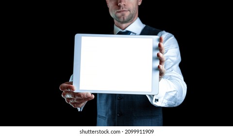 Tablet mockup. Businessman holding mobile tablet blank screen. Smart technology device mock up isolated on black background. Information message content with clipping path