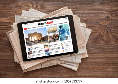 Tablet with news website on stack of newspapers. All contents are made up. - Shutterstock ID 1059533777
