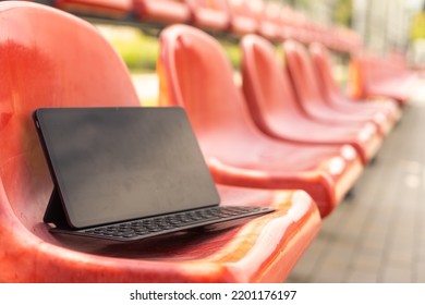 Tablet On Empty Tribune Of Stadium On Daytime