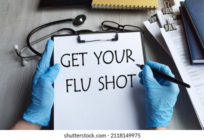 In The Tablet For Papers, The Inscription GET YOUR FLU SHOT, A Stethoscope, A Medical Mask, Pills And Gloves On The Desktop. View From Above. Healthcare Concept.