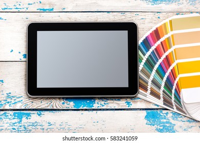 Tablet PC With Colour Swatches Book On The Table.