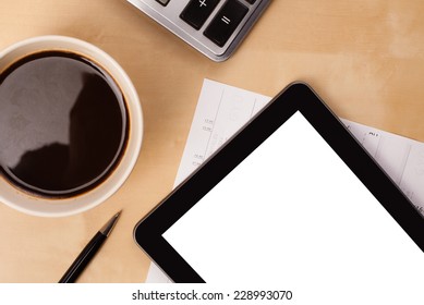 Tablet pc with copy space and a cup of coffee on a wooden work table close-up