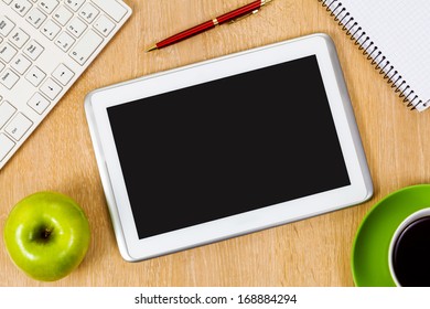 Tablet pc cup of coffee and notepad at table