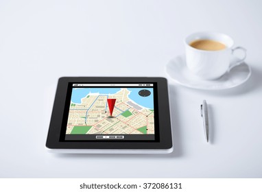tablet pc with gps navigator map and cup of coffee