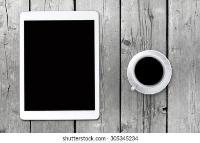 Tablet pc looking like ipad on table with coffee cup