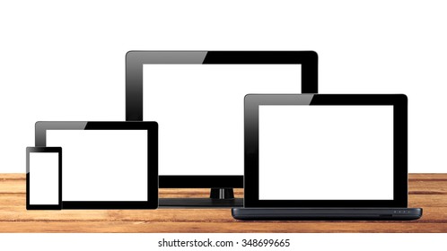 Tablet pc, mobile phone and computer on wooden table background