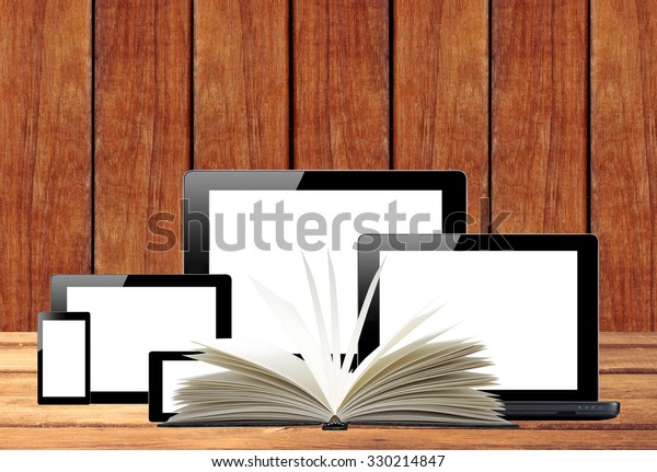 Tablet pc, mobile phone, computer and openned book\
on wooden table